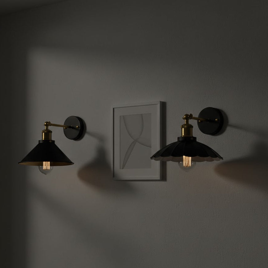 Two wall-mounted lights on a dark wall with a framed picture in the center.