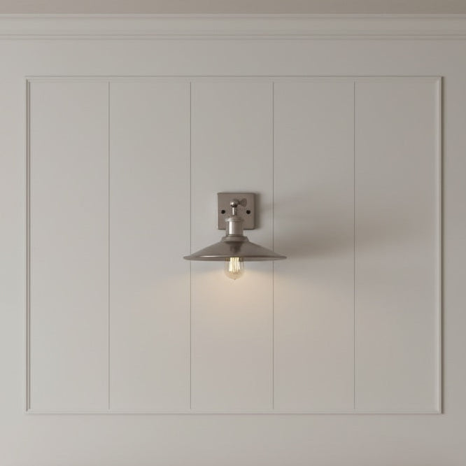 Wall-mounted light fixture on a gray paneled wall