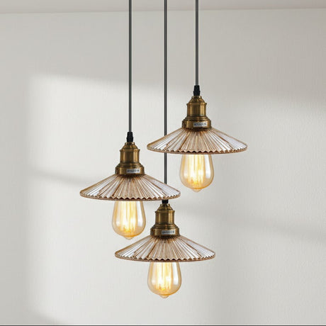 Three vintage-style pendant lights with glass shades on a plain background