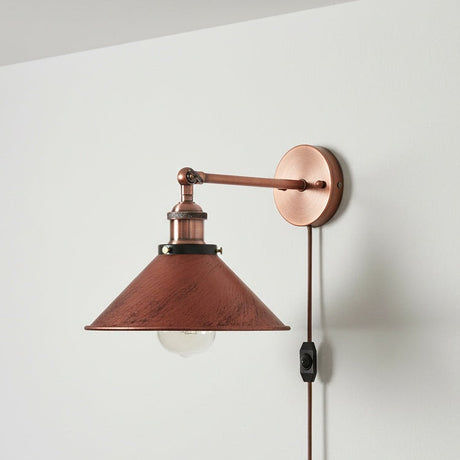 Wall-mounted lamp with copper finish on a white wall