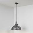 Pendant light with textured metal shade against a plain background