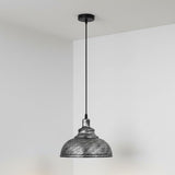 Pendant light with textured metal shade against a plain background