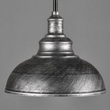 Metallic pendant light with a textured finish on a gray background