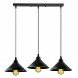 Three black pendant lights with exposed bulbs on a white background