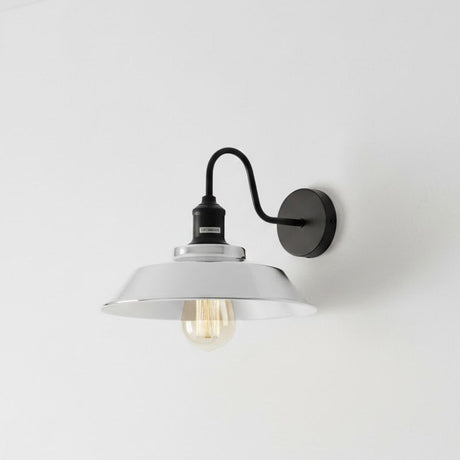 Wall-mounted light fixture with white shade and black metal arm on a light gray background