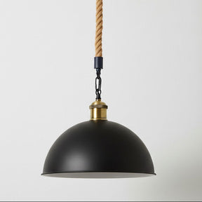 Black pendant light with gold accents and a rope cord on a white background