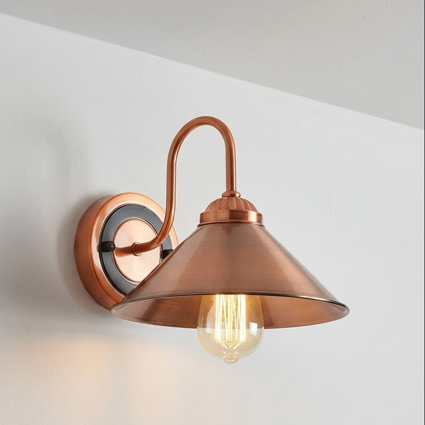 Copper wall sconce with a lit bulb on a white wall