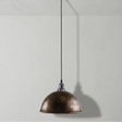 Bronze pendant light hanging against a plain white wall