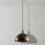Bronze pendant light hanging against a plain white wall