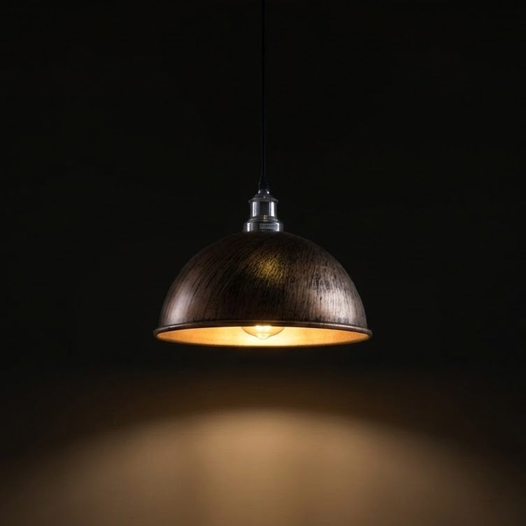 nickel pendant light with a warm glow on a dark background