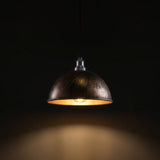nickel pendant light with a warm glow on a dark background