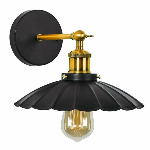 Black and gold wall-mounted light fixture with a visible bulb on a white background