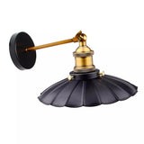 Wall-mounted lamp with black shade and gold fixture on a white background
