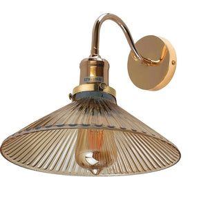 Gold wall-mounted lamp with a ribbed glass shade on a white background