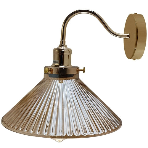 Gold wall-mounted lamp with a clear glass shade on a white background