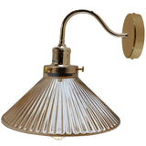 Gold wall-mounted lamp with a clear glass shade on a white background