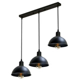 Black pendant light fixture with three hanging lights on a white background