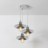 Modern pendant light fixture with three glass shades on a white background