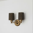 Brass wall sconce with two dark lampshades on a white background