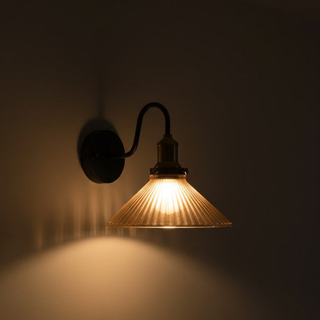 Wall-mounted light fixture casting a warm glow on a dark wall