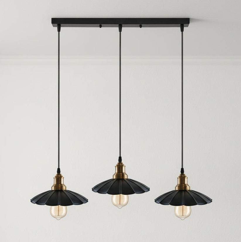 Three black pendant lights with gold accents on a gray background