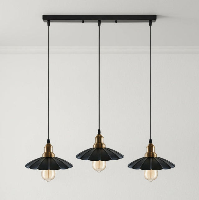 Three black pendant lights with gold accents on a gray background