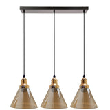 Three pendant lights with brown glass shades and gold accents on a white background