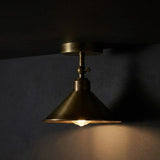 Brass ceiling light fixture on a dark wall