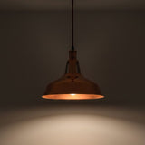 Bronze pendant light hanging against a dark background