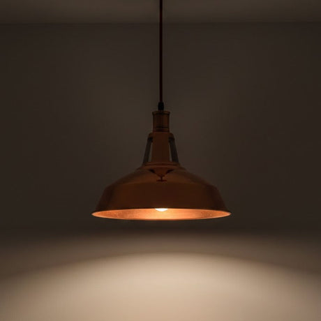 Bronze pendant light hanging against a dark background