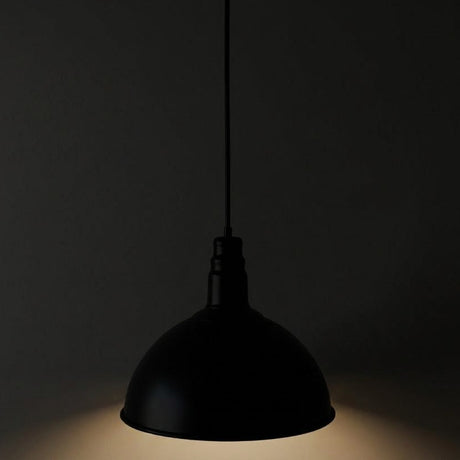 Black pendant light against a dark background