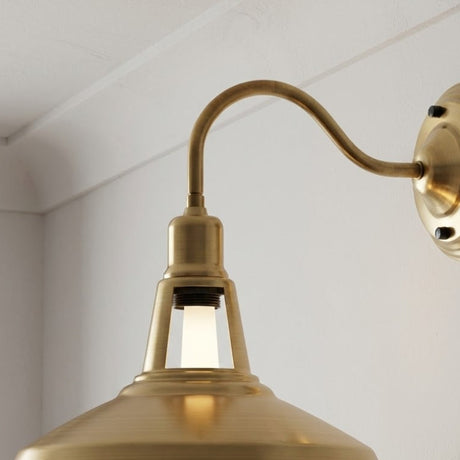 Brass wall-mounted light fixture with a white background