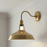 Brass wall-mounted light fixture on a white wall