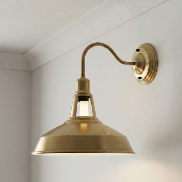 Brass wall-mounted light fixture on a white wall