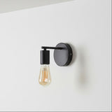 Modern wall light fixture with a black finish on a white wall