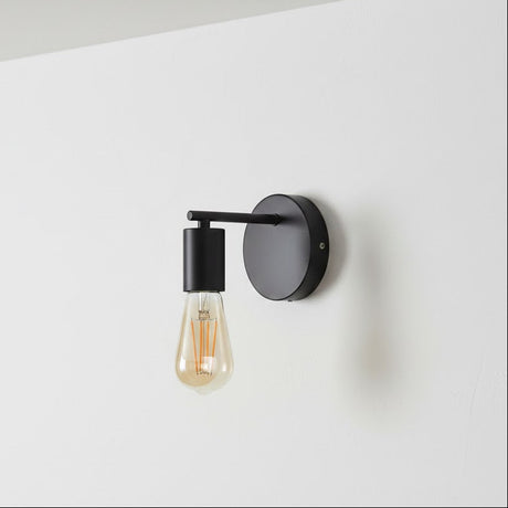 Modern wall light fixture with a black finish on a white wall