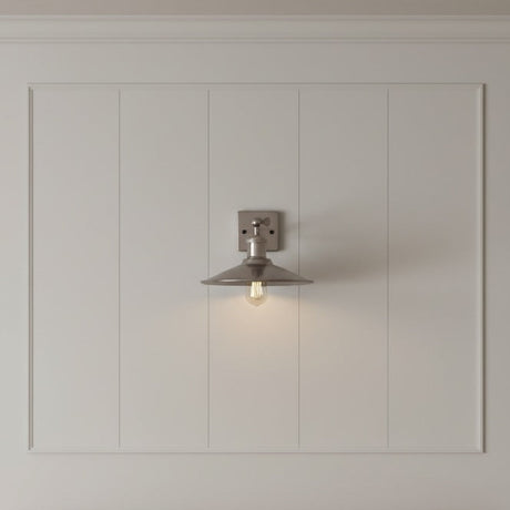 Wall-mounted light fixture on a gray paneled wall
