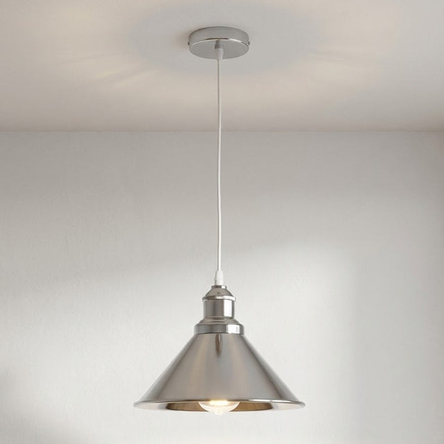 Metal pendant light hanging from a ceiling against a neutral background