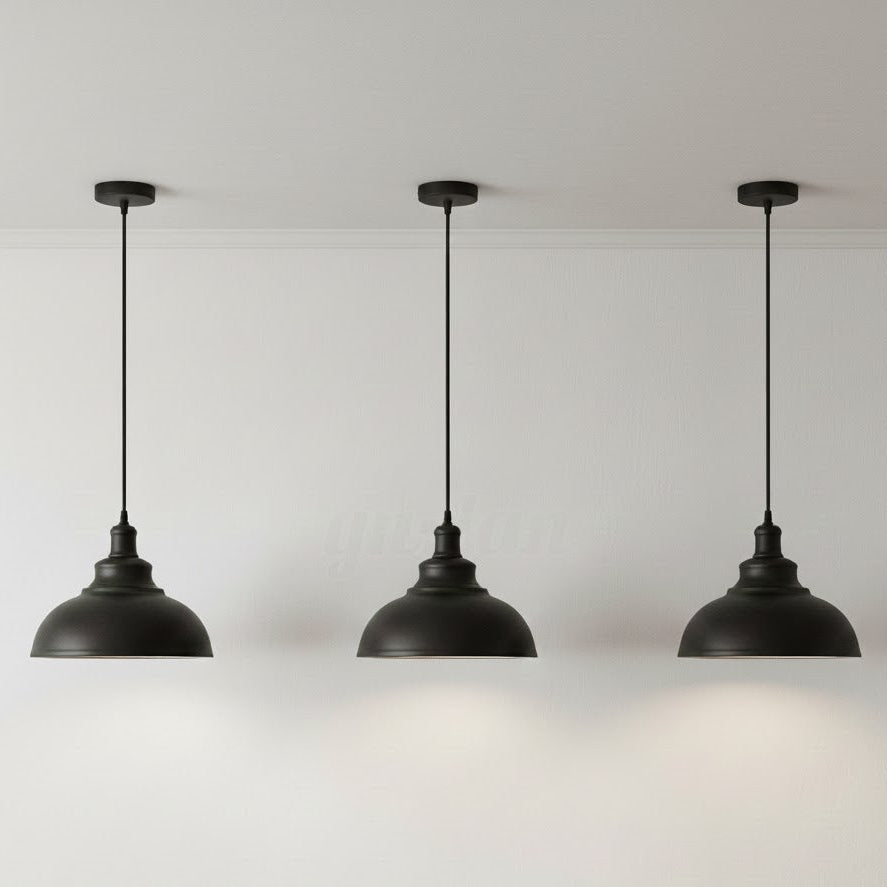 Three black pendant lights hanging against a white background