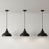 Three black pendant lights hanging against a white background