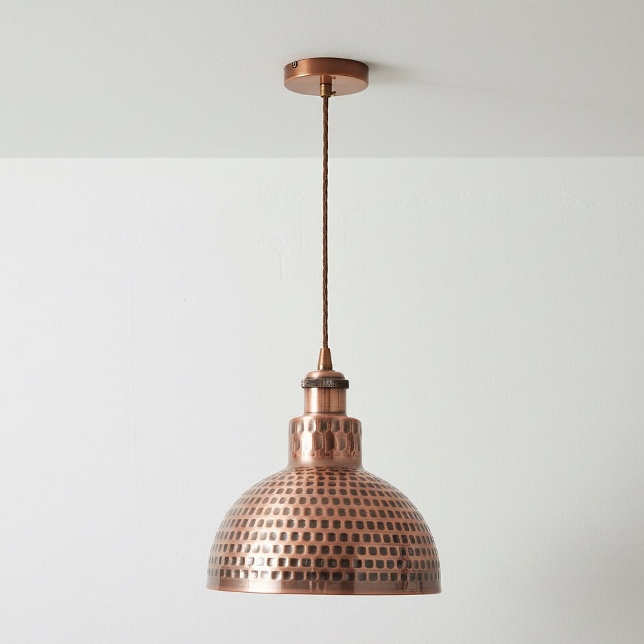 Copper pendant light fixture on a white background