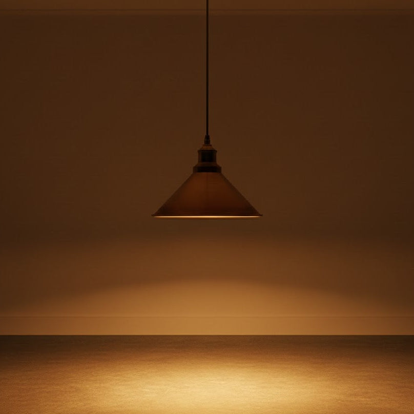 Brown pendant light hanging against a brown wall with a reflective surface.