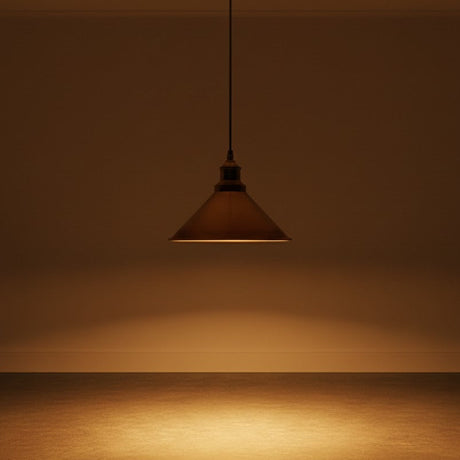 Brown pendant light hanging against a brown wall with a reflective surface.